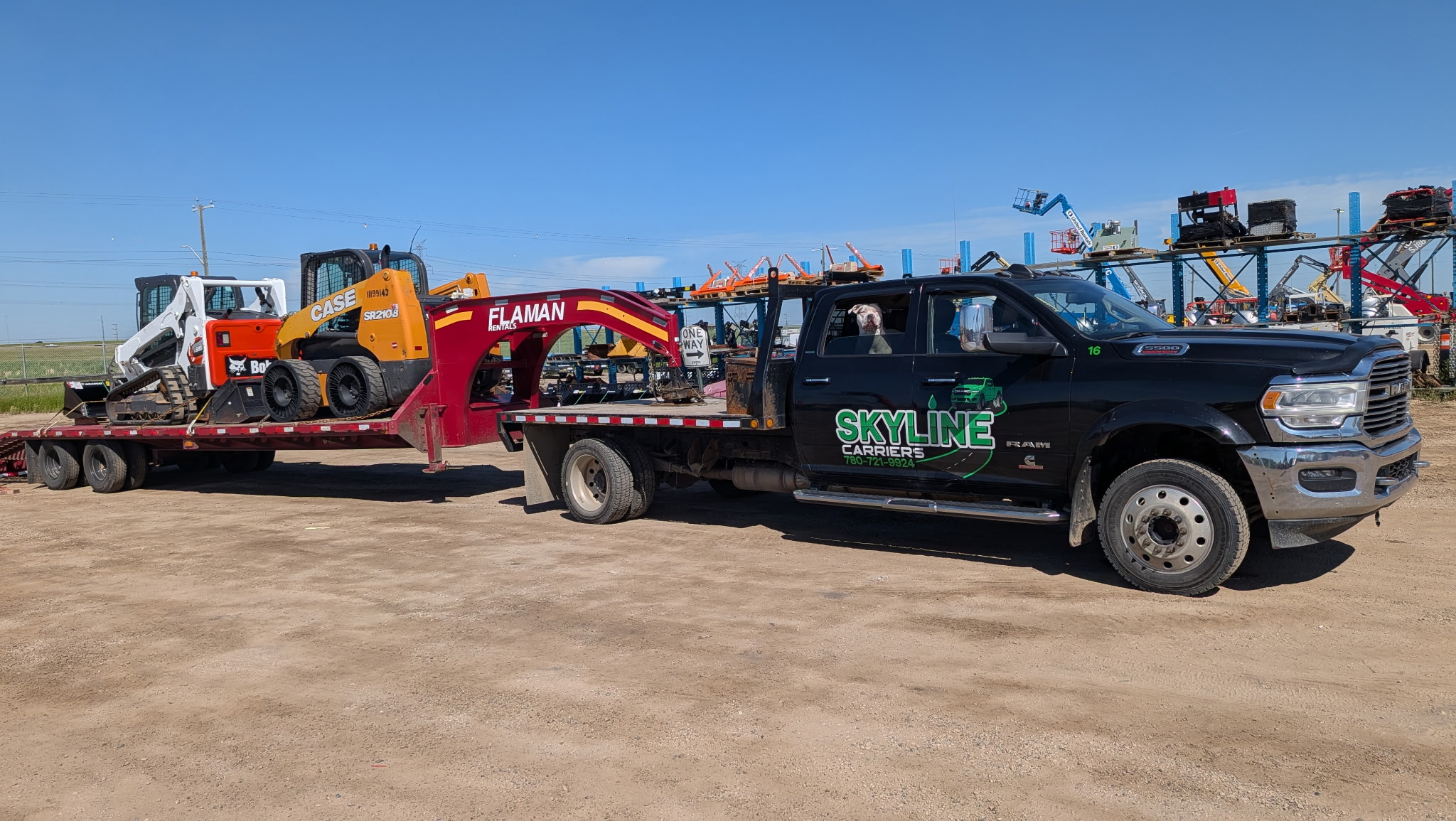 Ram dually with a gooseneck carrying a skid steer