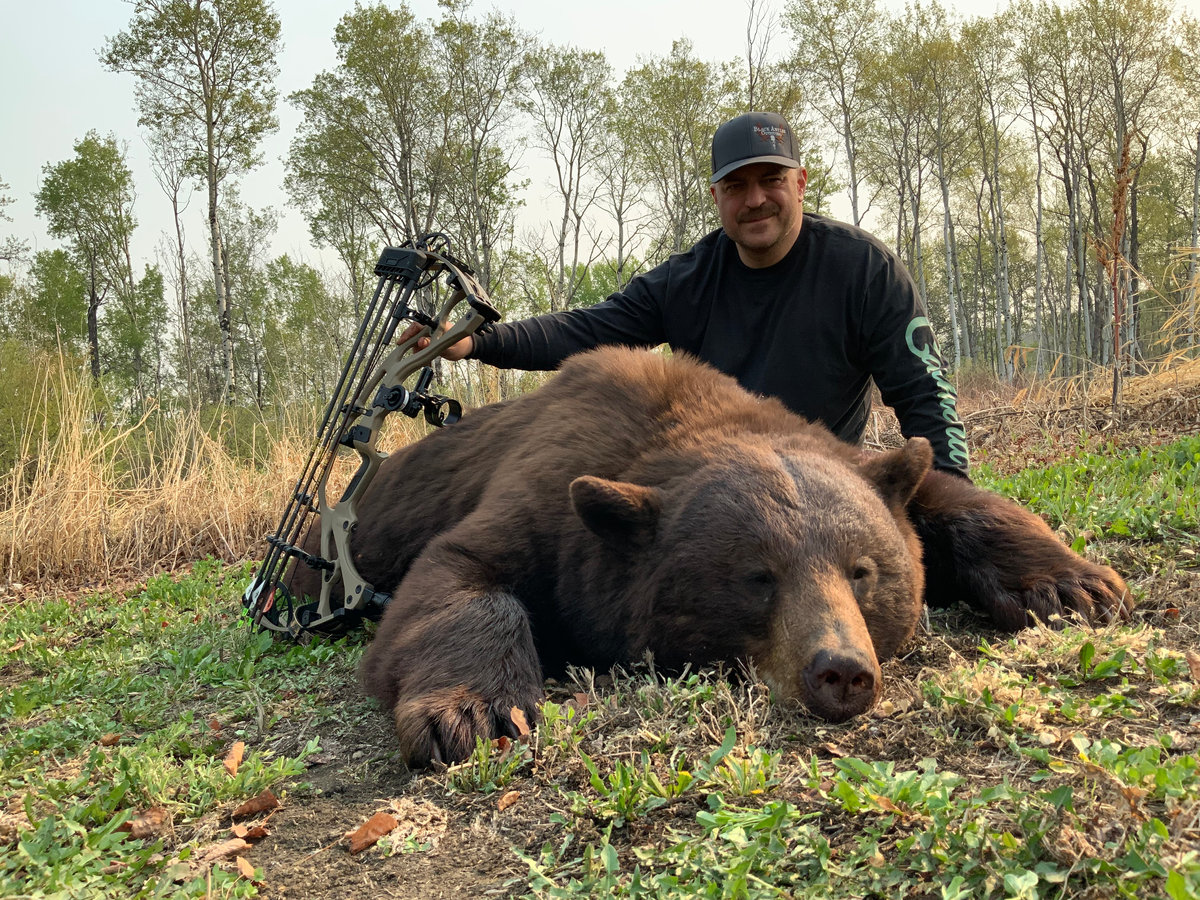 Bowhunter with a black bear