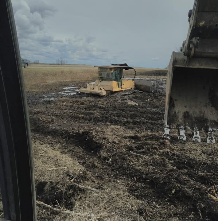 Yellow tracked clearing machine in mud