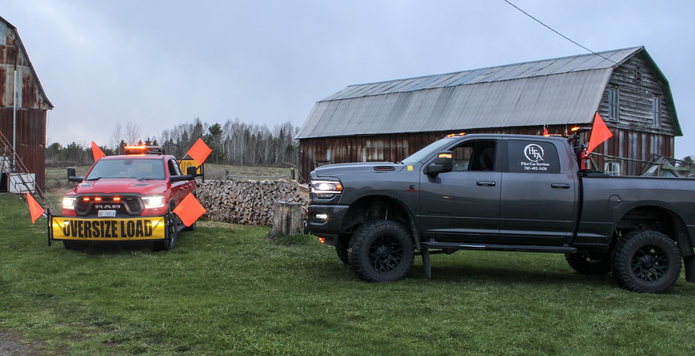 Red and grey pilot trucks in front of a barn