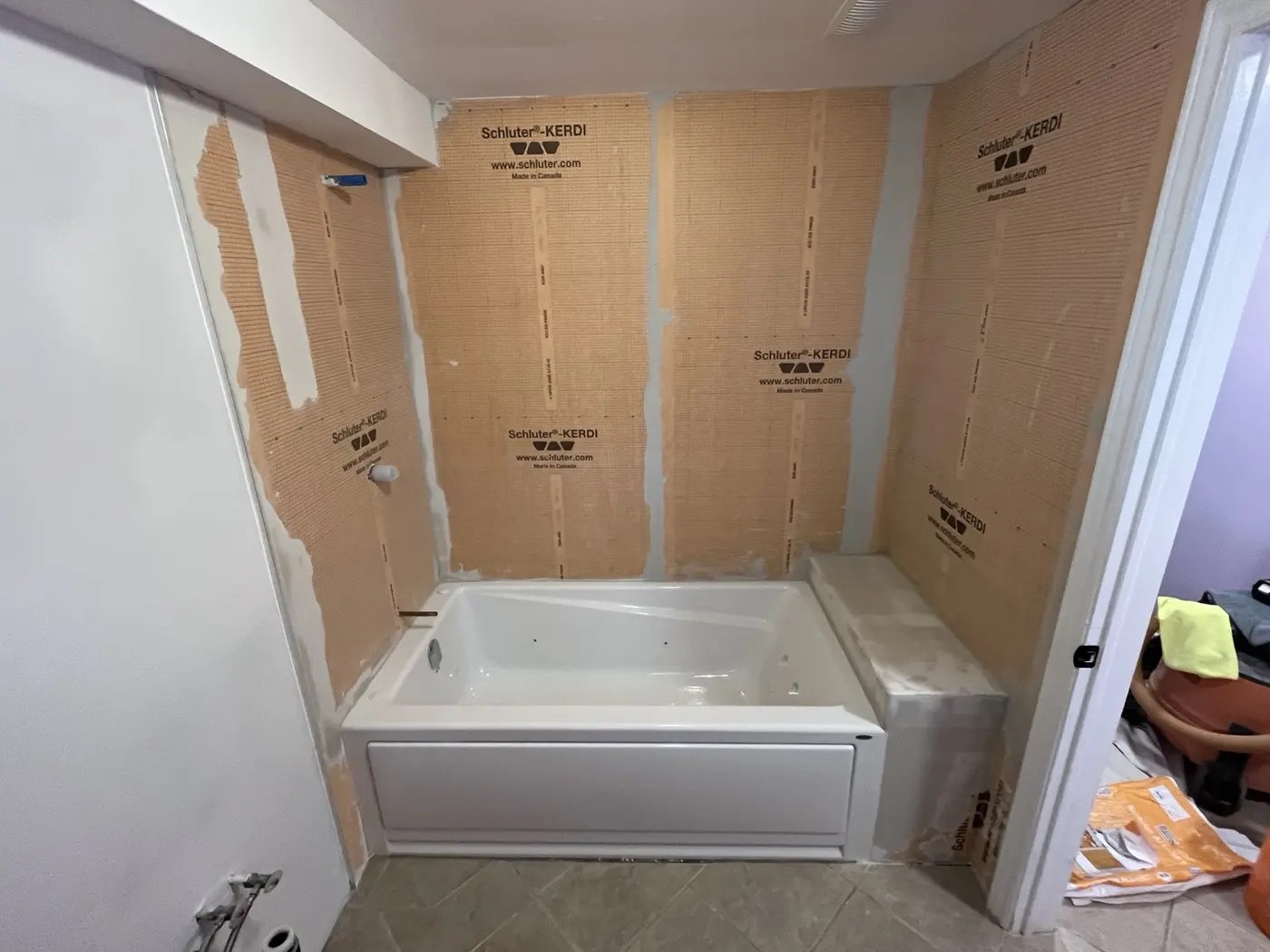 Tub surround with waterproofing membrane before tile