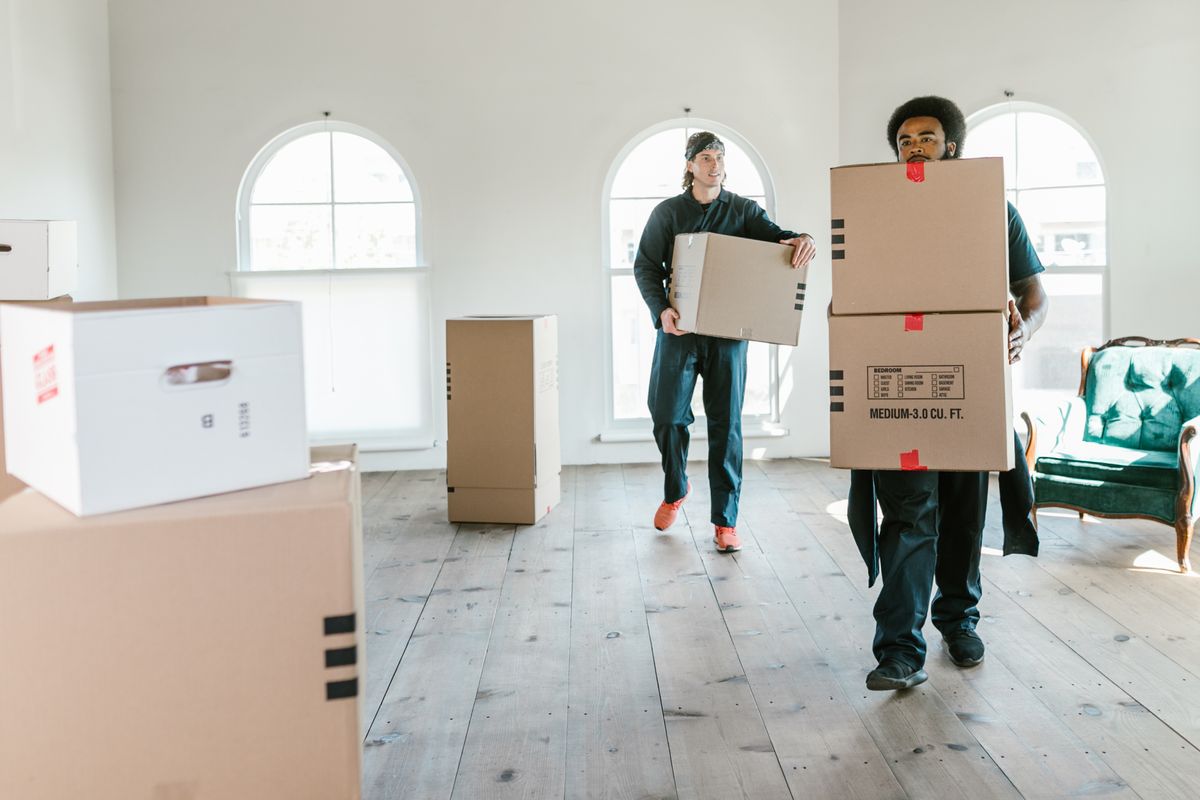 Movers carrying boxes into a house