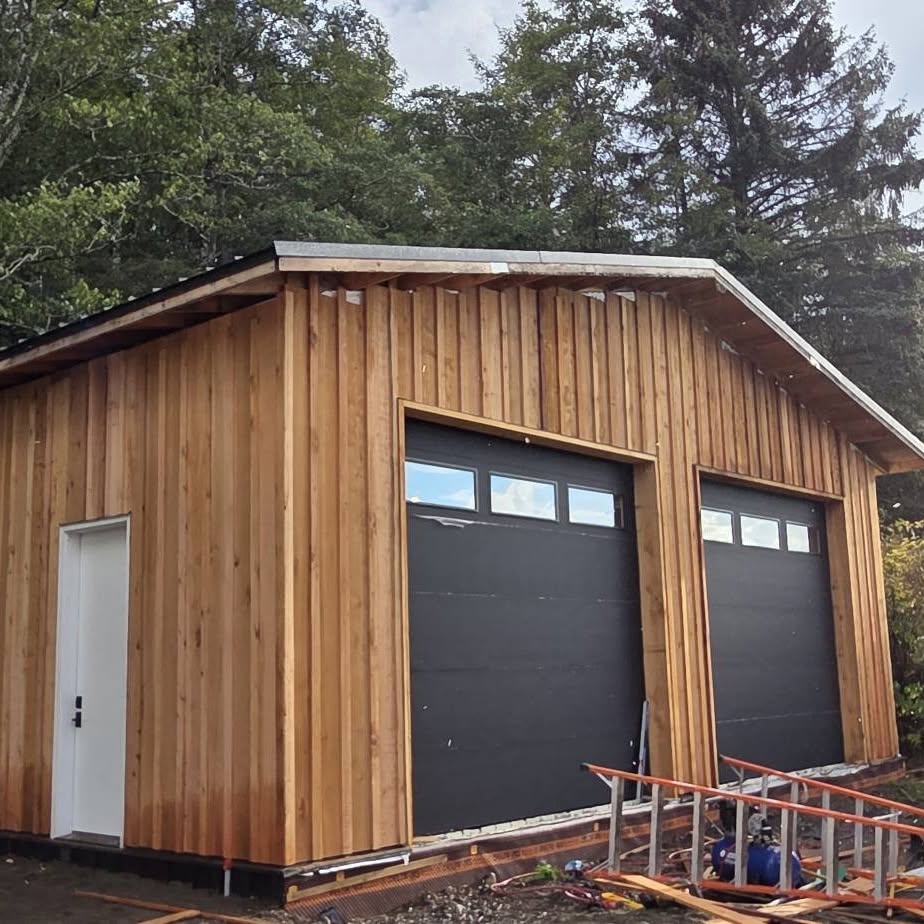 Freshly finished concrete slab beside a cedar-sided wall