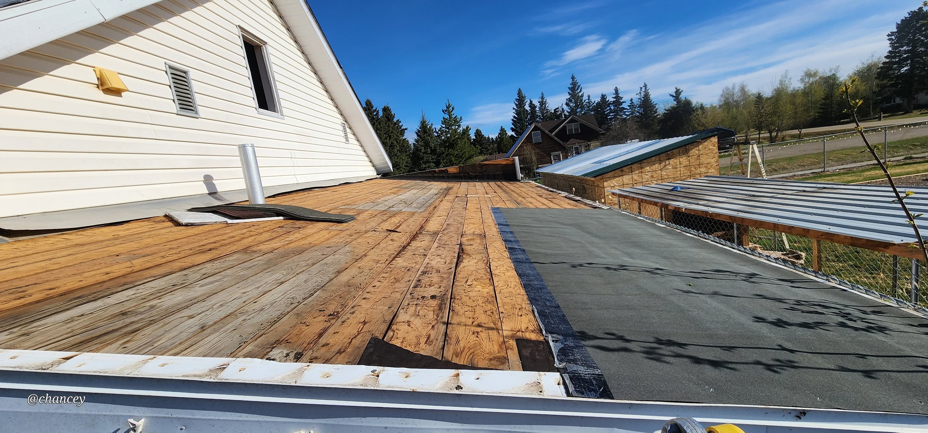 Finished wooden deck with fence beside a house in Peace River